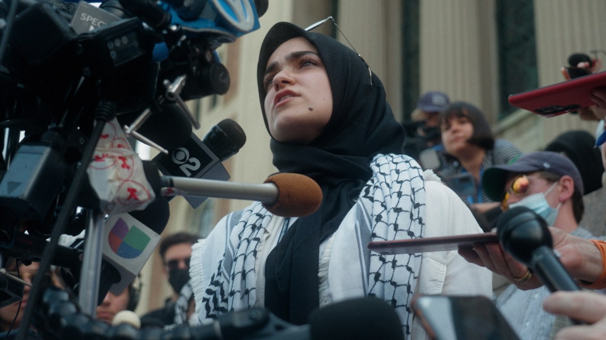 A protester raises their fist at Columbia University during the Gaza solidarity encampments, featured in The Encampments documentary.